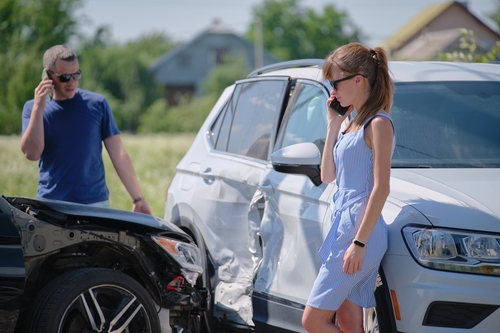 Roadside assistance technician helping a stranded driver with a jump start and tire change in Humble, TX